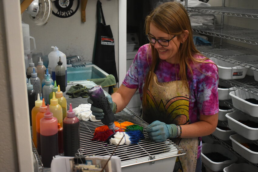 Katie DeGroot, business owner in Englewood, tie dyes a shirt in her shop on S. Broadway on Aug. 23, 2023.